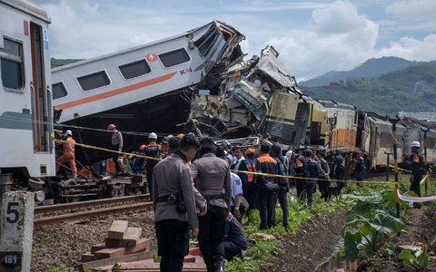 Rettungskräfte inspizieren die Zugwracks nach dem Zusammenstoß: In beiden Zügen waren insgesamt 478 Menschen unterwegs. - Foto: Abdan Syakura/AP/dpa