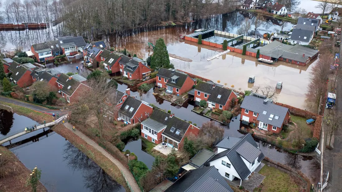 Häuser im Hochwassergebiet in der Gemeinde Lilienthal bei Bremen. Weil das überflutete Gebiet zu groß ist, um erfolgreich abzupumpen, errichten Feuerwehrleute eine Barriere mit Sandsäcken. So wird ein Teil der überfluteten Fläche abgetrennt. - Bild: Sina Schuldt/dpa