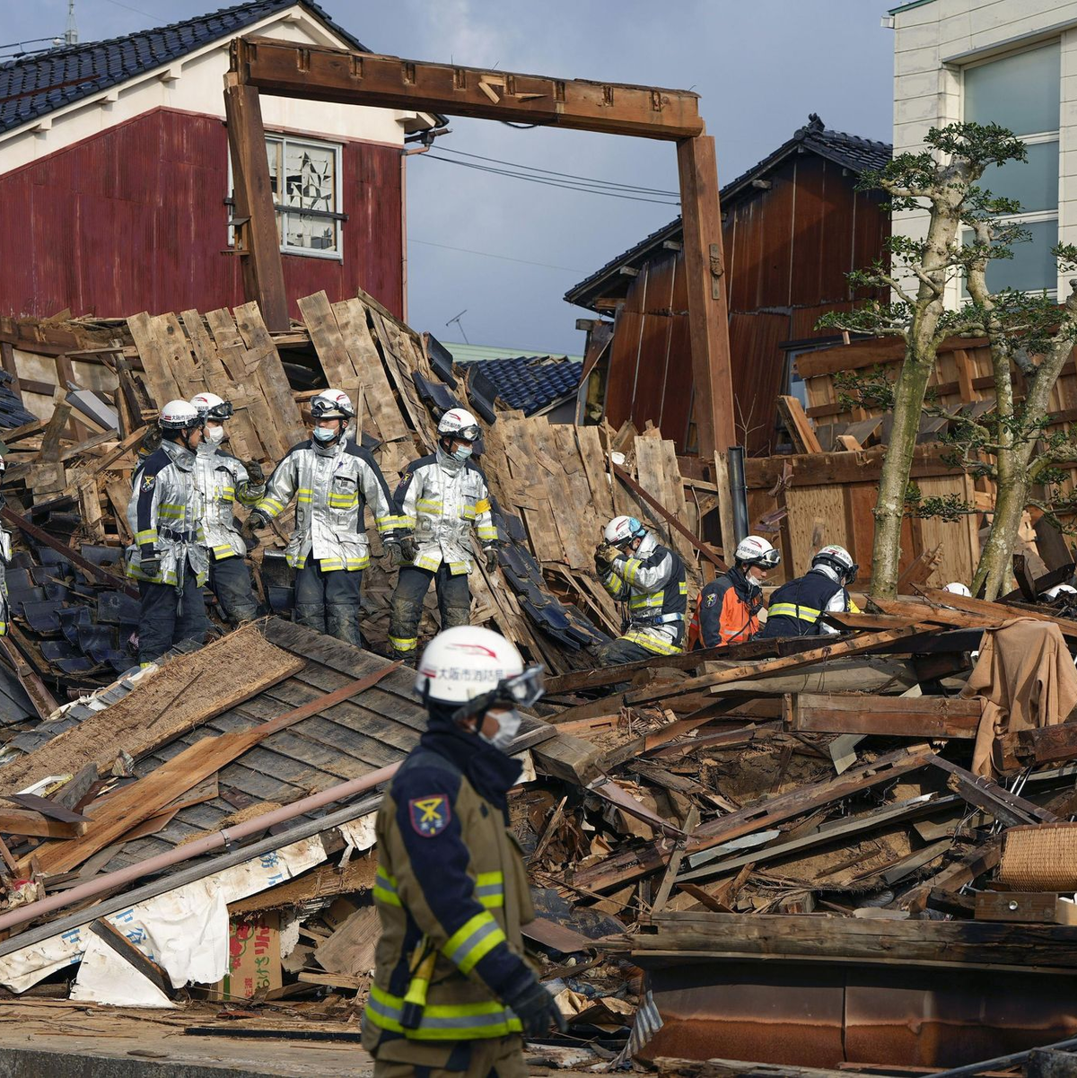 Rettungskräfte arbeiten an einem eingestürzten Gebäude in Wajima. - Foto: -/kyodo/dpa