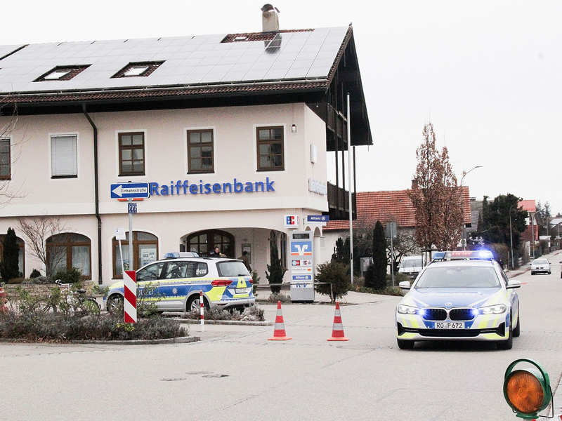Einsatzkräfte der Polizei nach dem Überfall auf einen Geldtransporter in der Nähe einer Bank in Großkarolinenfeld in Bayern. - Foto: Josef Reisner/dpa
