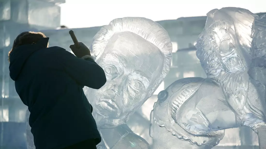 Ein Teilnehmer des Wettbewerbs arbeitet an einer Eisskulptur beim Internationalen Eisskulpturenwettbewerb. - Bild: Wang Jianwei/XinHua/dpa