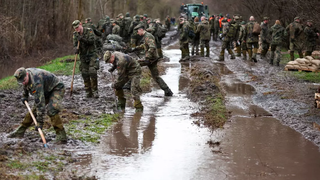 Soldatinnen und Soldaten der Bundeswehr sichern einen Deich an der Helme in Sachsen-Anhalt mit Sandsäcken. - Bild: Jan Woitas/dpa