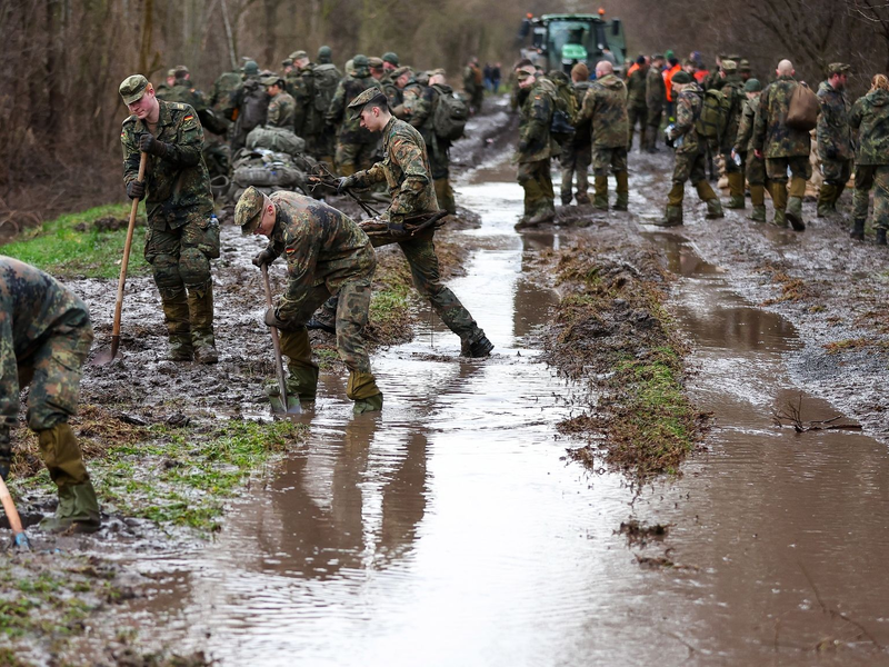 Soldatinnen und Soldaten der Bundeswehr sichern einen Deich an der Helme mit Sandsäcken. - Foto: Jan Woitas/dpa