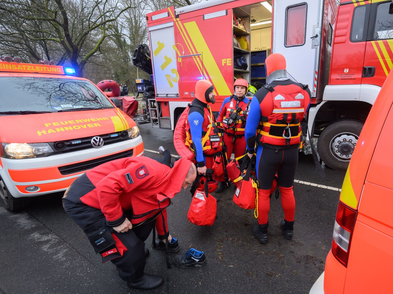 Einsatzkräfte der Wasserrettung der Feuerwehr Hannover auf einer überfluteten Straße zwischen Hannover und Hemmingen. Ein Mann war mit dem Fahrrad auf einer gesperrten Straße im tiefen Wasser gestürzt und weggespült worden. - Foto: Julian Stratenschulte/dpa