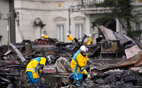 Polizeibeamte suchen nordwestlich von Tokio nach Opfern eines durch das Erdbeben verursachten Brandes. - Foto: Hiro Komae/AP