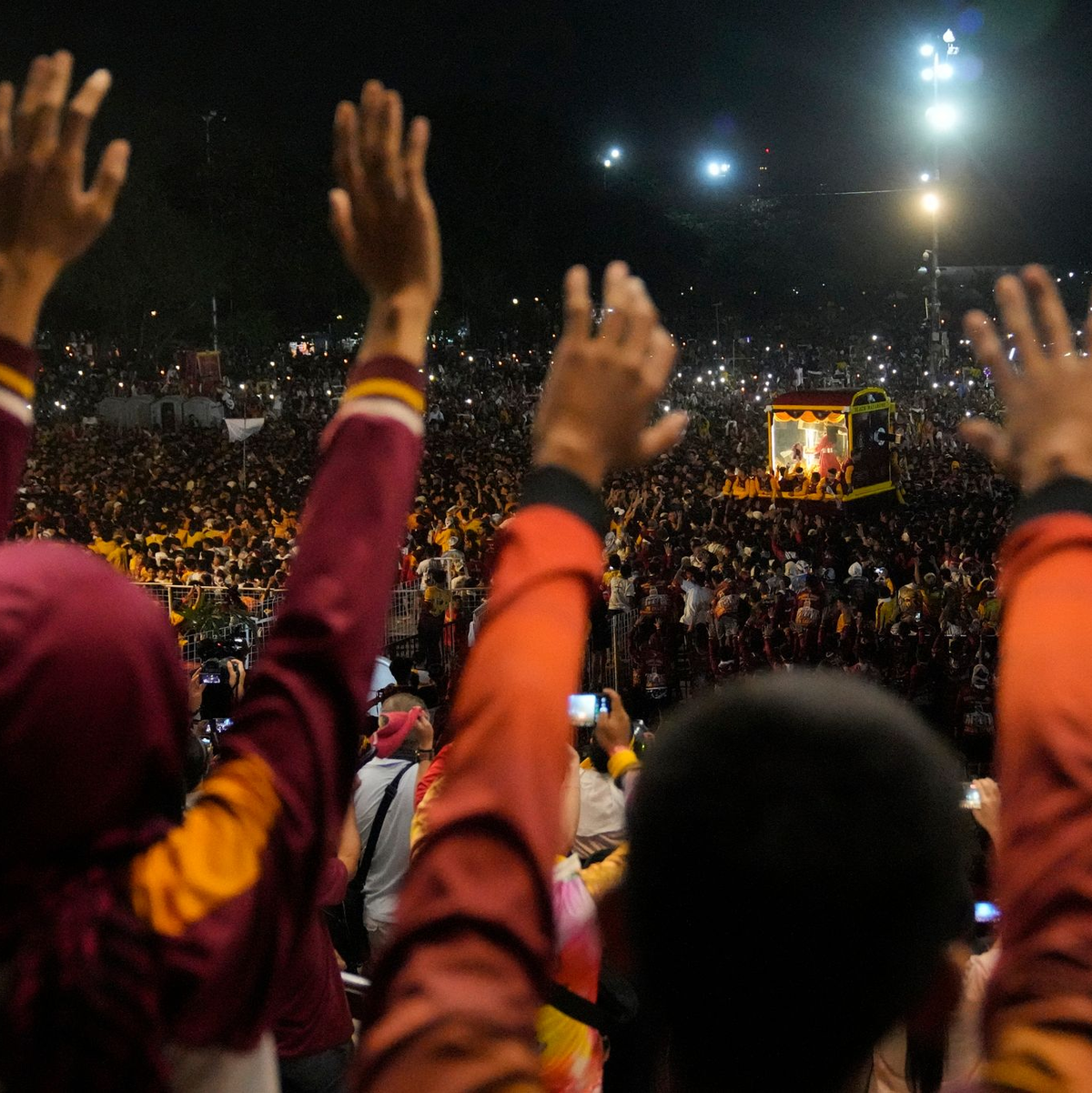 Gläubige erheben ihre Hände während der Prozession. - Foto: Aaron Favila/AP/dpa