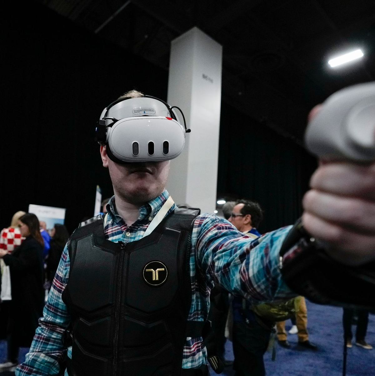 Ein Besucher probiert auf der CES die haptische Weste von bHaptics. Die Weste soll in Verbindung mit Augmented-Reality-Systemen verwendet werden, um haptisches Feedback in Videospielen zu geben. - Foto: Ryan Sun/AP/dpa