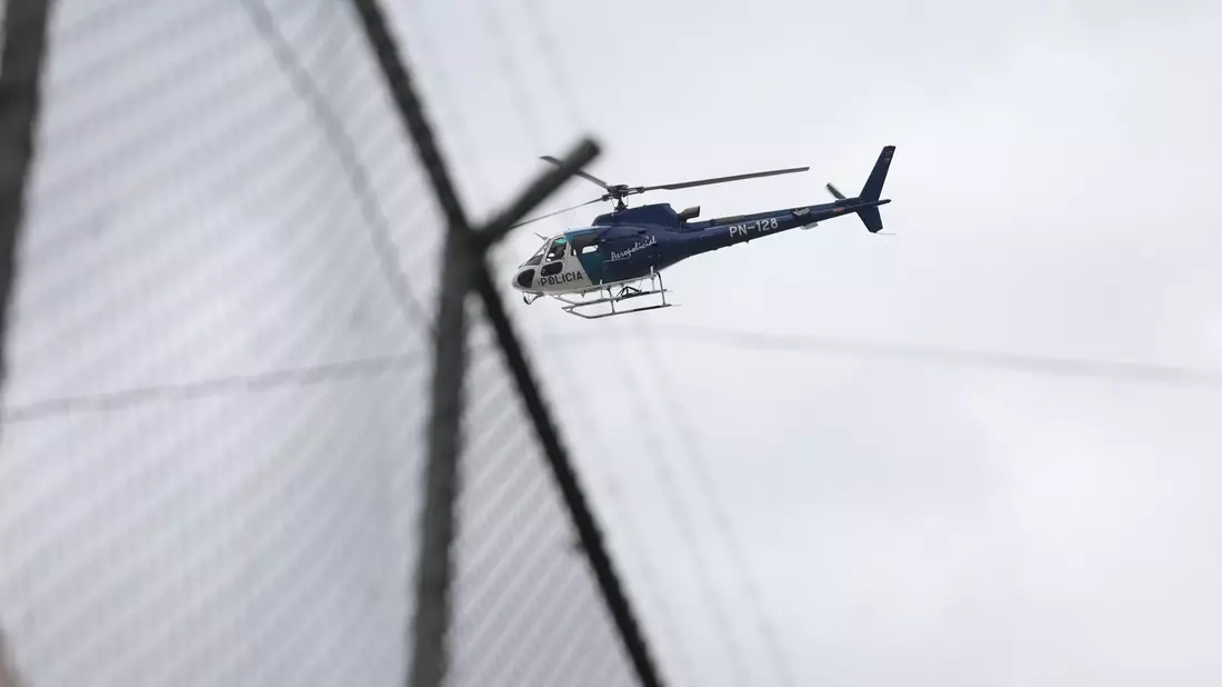 Ein Hubschrauber fliegt über dem Zaun des Gefängnisses Inca im Norden von Quito. - Bild: Juan Diego Montenegro/dpa