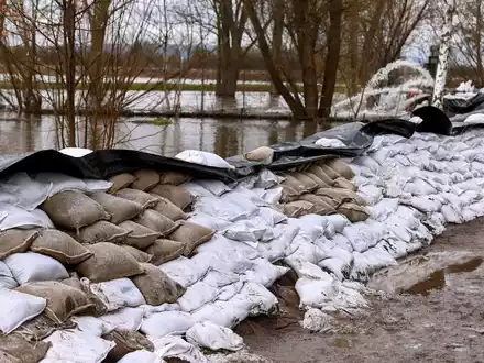 Einen großen Damm aus Sandsäcken haben freiwillige Helfer und Feuerwehren in den letzten Tagen an der Helme errichtet. - Foto: Heiko Rebsch/dpa