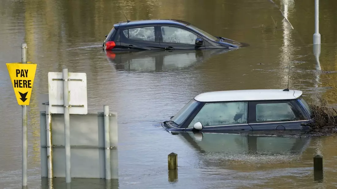 Autos auf einem überfluteten Parkplatz im britischen Wallingford. - Bild: Andrew Matthews/PA Wire/dpa
