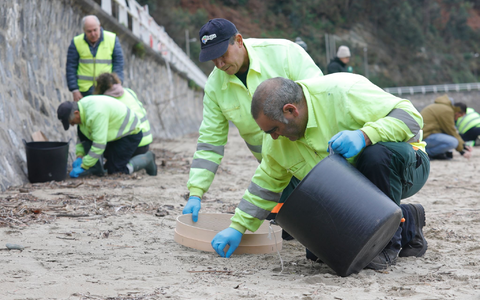 In mühsamer Handarbeit werden die Plastikkügelchen aufgesammelt. - Foto: Jorge Peteiro/EUROPA PRESS/dpa