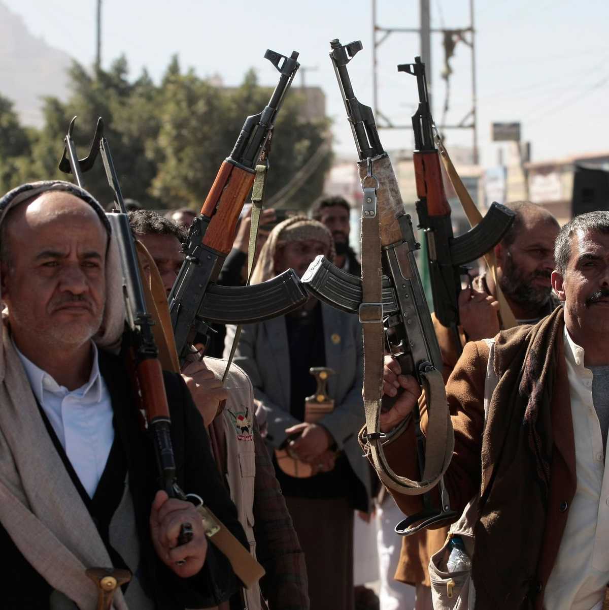 Neu rekrutierte Huthi-Kämpfer halten bei einer Zeremonie am Ende ihrer Ausbildung Waffen hoch und rufen Parolen. - Foto: Osamah Yahya/ZUMA Press Wire/dpa