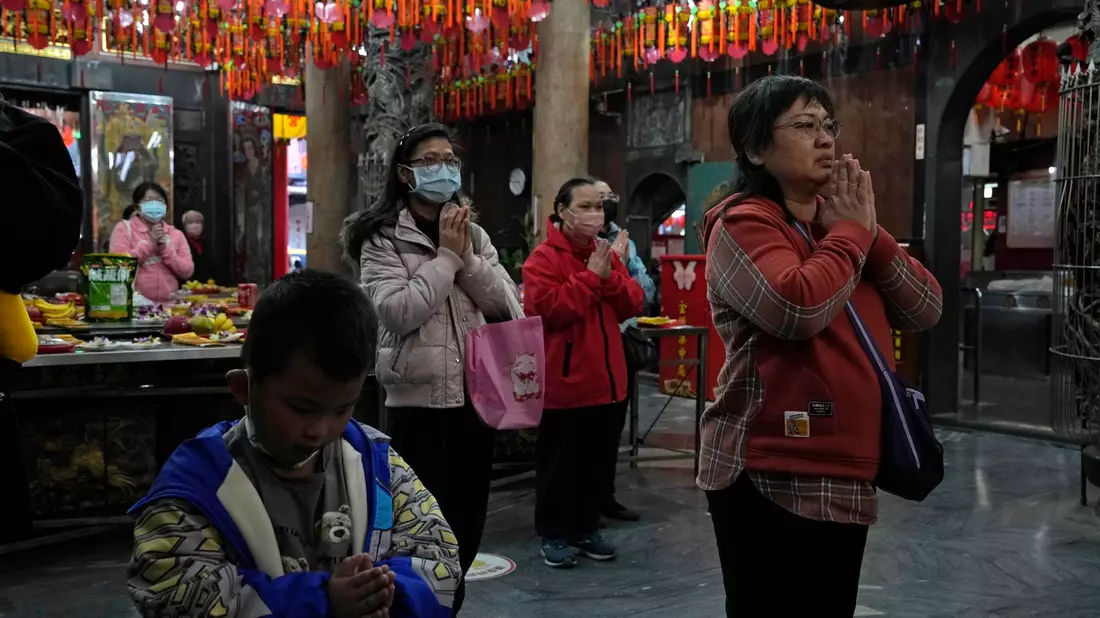 Menschen beten in einem Tempel, der als Wahllokal genutzt wurde. - Bild: Ng Han Guan/AP