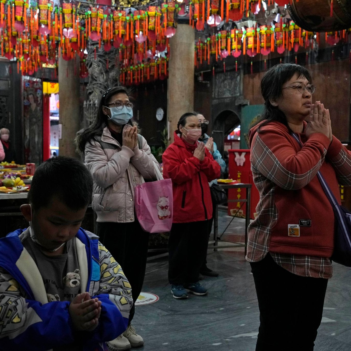 Menschen beten in einem Tempel, der als Wahllokal genutzt wurde. - Foto: Ng Han Guan/AP