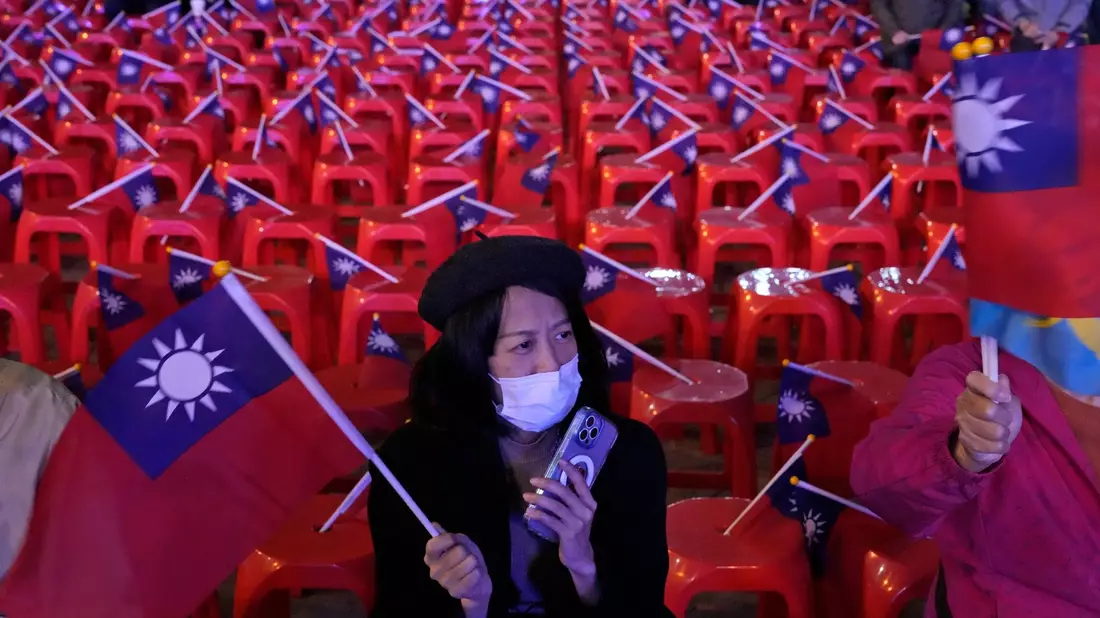 Warten auf das Ergebnis der Wahl: Eine Frau schwenkt die Nationalflagge von Taiwan. - Bild: Ng Han Guan/AP/dpa