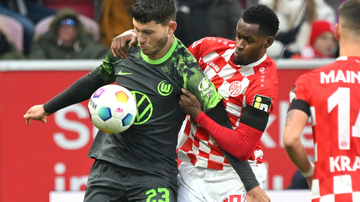 Wolfsburgs Jonas Wind (l) schirmt den Ball vor dem Mainzer Edmilson Fernandes ab. - Foto: Torsten Silz/dpa