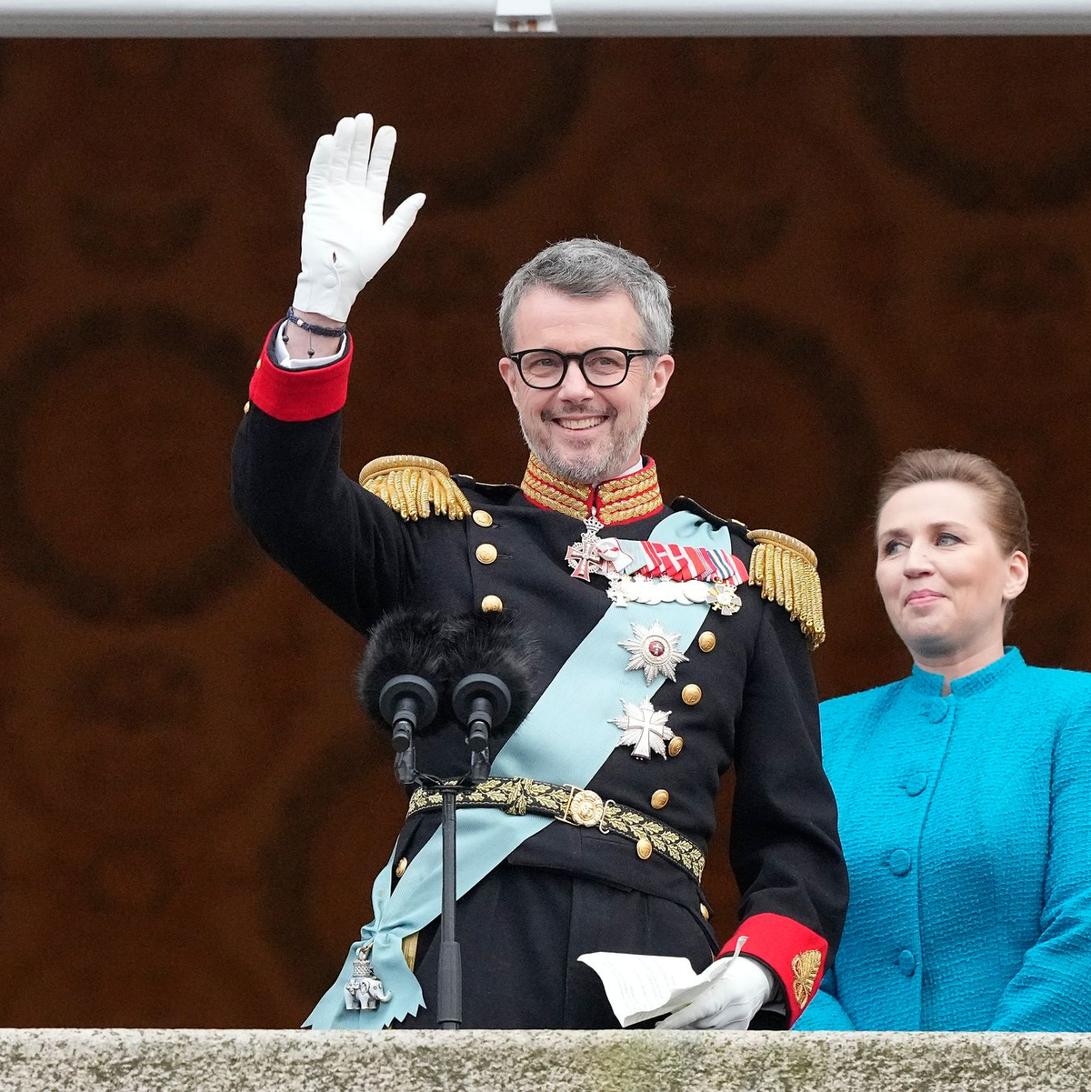 König Frederik X. von Dänemark winkt vom Balkon des Schlosses Christiansborg, während die dänische Ministerpräsidentin Mette Frederiksen zusieht. - Foto: Martin Meissner/AP