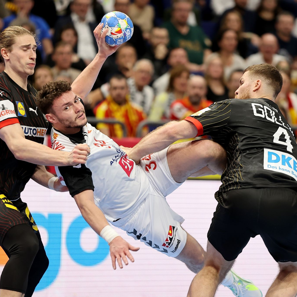 Die deutsche Defensive hält: Tomislav Jagurinovski aus Mazedonien (M) bleibt an Juri Knorr (l) und Johannes Golla (r) hängen. - Foto: Andreas Gora/dpa