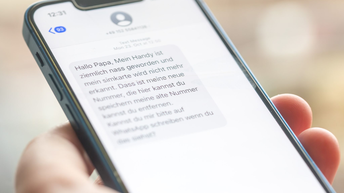 Eine Frau hält ein Smartphone in ihrer Hand, auf dessen Display eine Betrugs-SMS zu lesen ist. - Foto: Fernando Gutierrez-Juarez/dpa