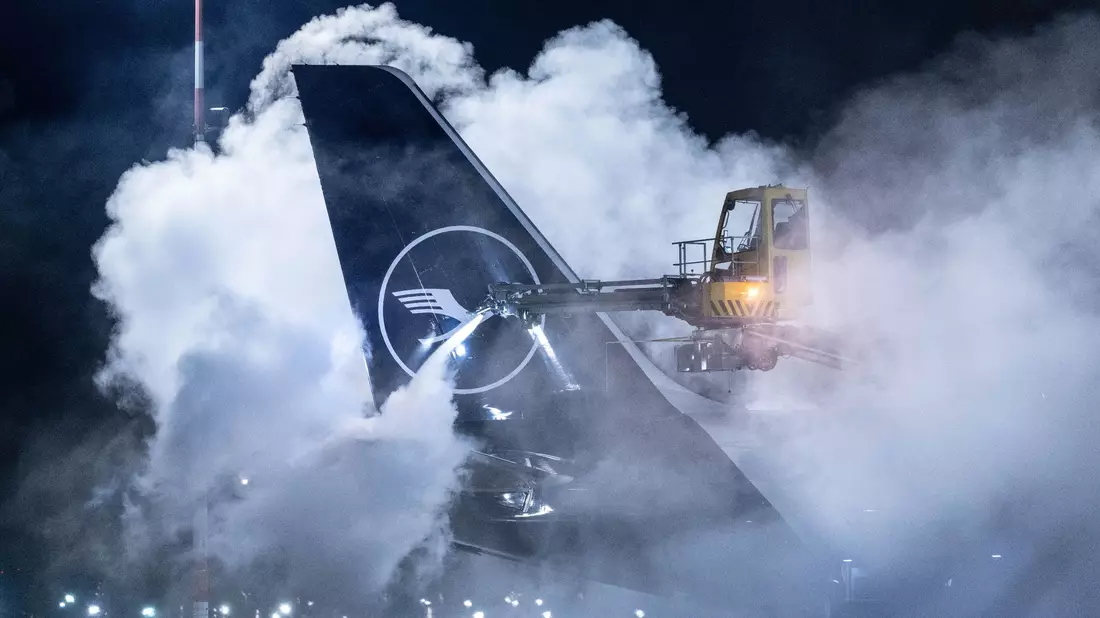 Eine Lufthansa-Maschine wird auf dem Flughafen Frankfurt enteist. Angesichts der Wetterlage hat der Flughafen den Flugplan zusammengestrichen. - Bild: Boris Roessler/dpa