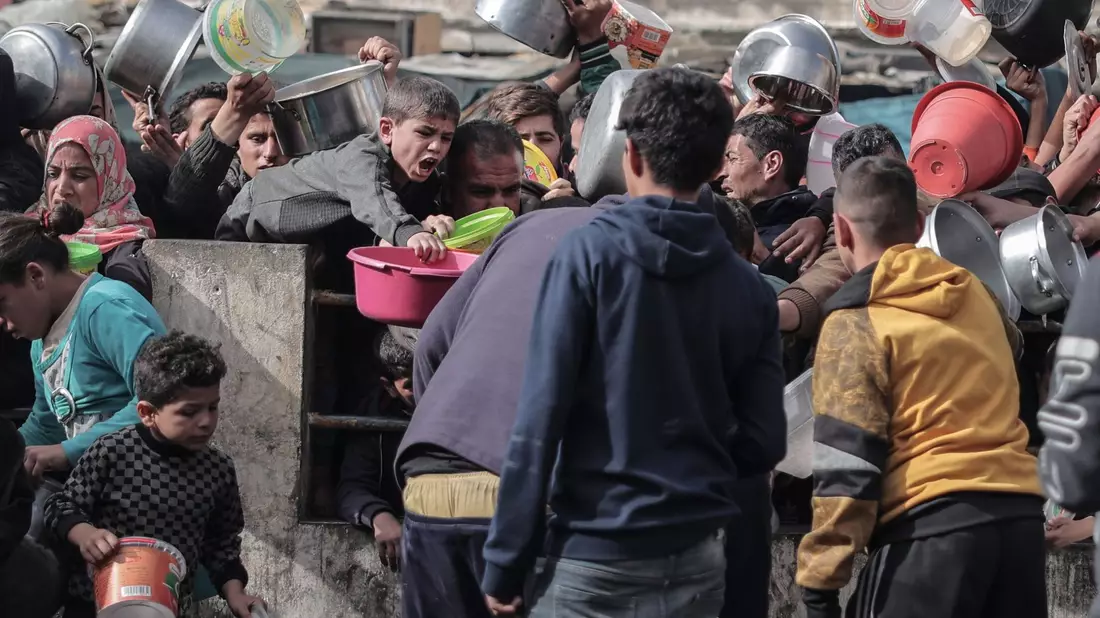Palästinenser warten an einer Spendenstelle in einem Flüchtlingslager im südlichen Gazastreifen auf Lebensmittel. - Bild: Bashar Taleb/APA/ZUMA/dpa