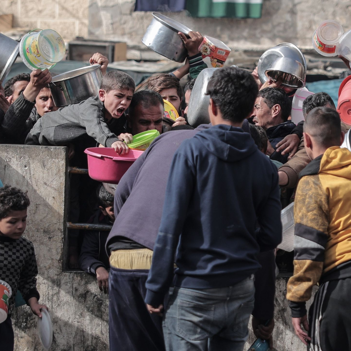 Palästinenser warten an einer Spendenstelle in einem Flüchtlingslager im südlichen Gazastreifen auf Lebensmittel. - Foto: Bashar Taleb/APA/ZUMA/dpa