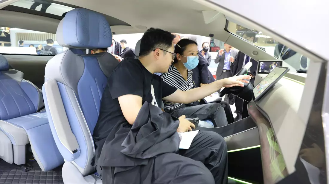 Besucher probieren ein HarmonyOS-basiertes intelligentes Bordcomputerterminal am Huawei-Stand auf der 20. internationalen Automobilausstellung «Auto Shanghai 2023». - Bild: Fang Zhe/XinHua/dpa