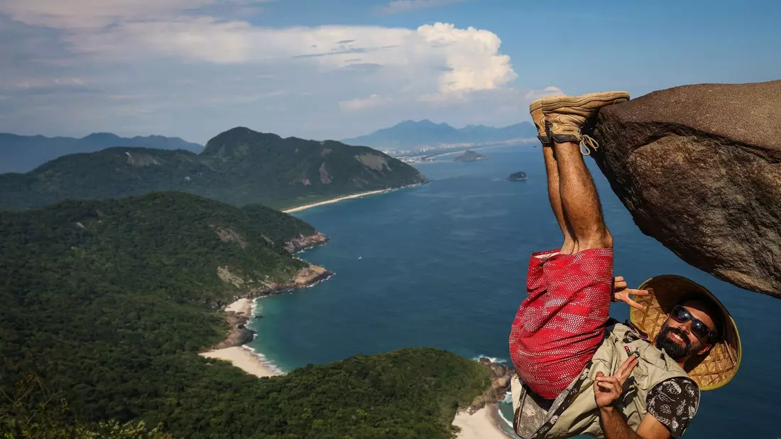 Ein Mann hängt für ein Bild an dem Felsen «Pedra do Telegrafo» bei Rio de Janeiro. - Bild: Aline Massuca/