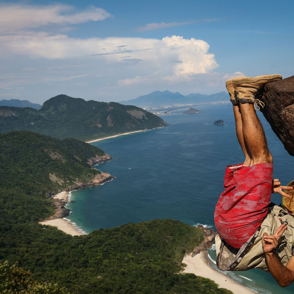 Ein Mann hängt für ein Bild an dem Felsen «Pedra do Telegrafo» bei Rio de Janeiro. - Foto: Aline Massuca/