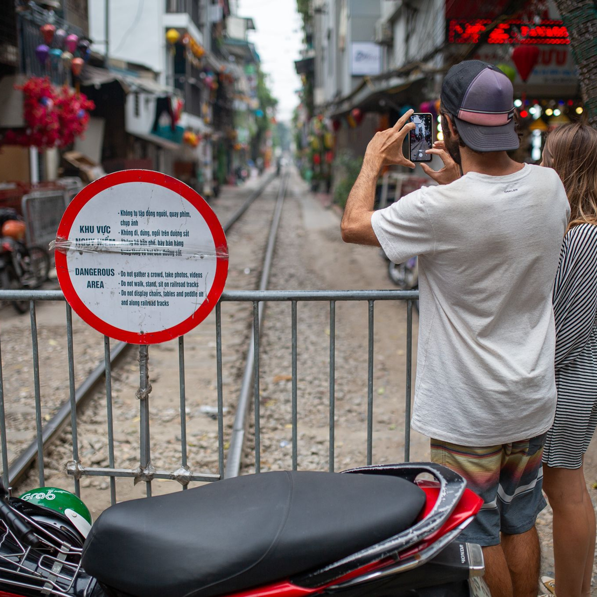 Zwei Touristen aus Brasilien fotografieren die abgesperrte «Train Street» in Hanoi. - Foto: Chris Humphrey/dpa