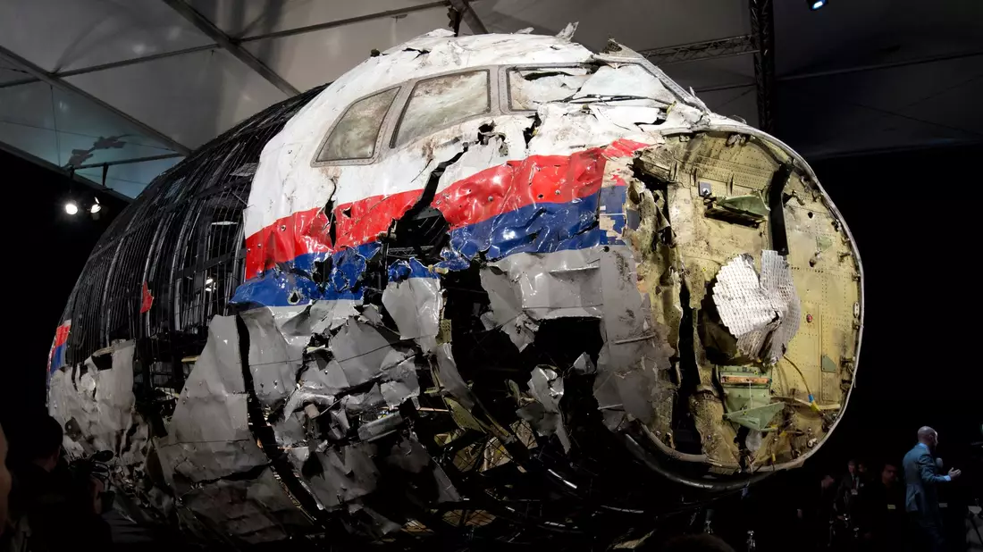 Die aus Trümmern teilweise wieder zusammengesetzte Boeing 777 der Malaysia Airlines, die als Flug MH17 über der Ukraine abgeschossen wurde, steht in einer Halle in Gilze-Rijen in den Niederlanden. - Bild: Peter Dejong/AP/dpa