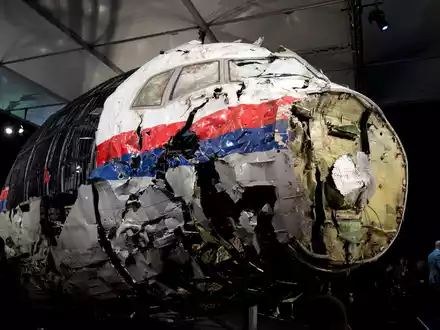 Die aus Trümmern teilweise wieder zusammengesetzte Boeing 777 der Malaysia Airlines, die als Flug MH17 über der Ukraine abgeschossen wurde, steht in einer Halle in Gilze-Rijen in den Niederlanden. - Foto: Peter Dejong/AP/dpa