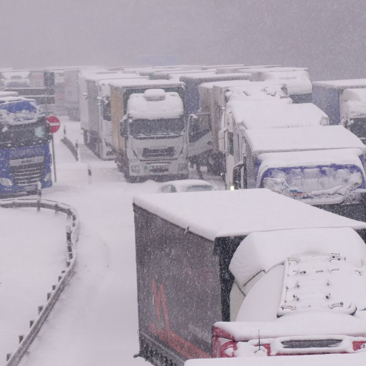 Lastwagen stecken im Stau auf der schneebedeckten Autobahn 5 bei Alsfeld fest. - Foto: Bernd März/dpa