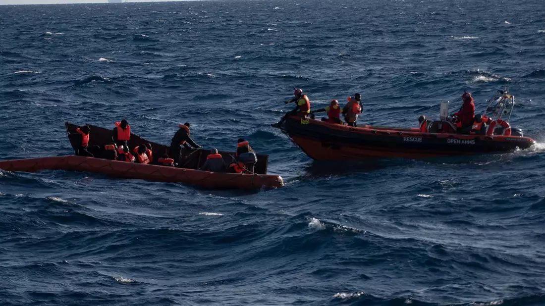 Migranten sitzen in einem Boot im Mittelmeer; Rettungskräfte versuchen, ihnen zu helfen. - Bild: Antonio Sempere/EUROPA PRESS/dpa
