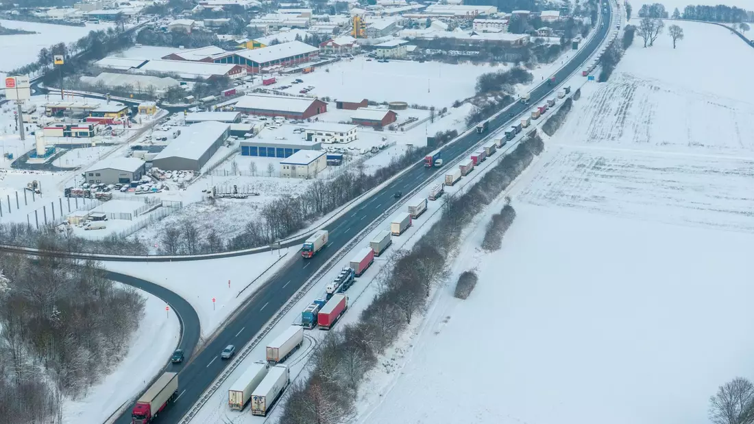 LKW auf der Autobahn A5 Richtung Norden stehen bei Schnee und Eis im Stau. - Bild: Stefan Weber/Fuldamedia/dpa