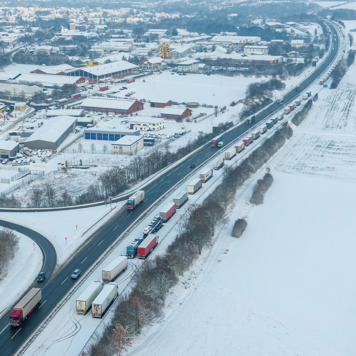 LKW auf der Autobahn A5 Richtung Norden stehen bei Schnee und Eis im Stau. - Foto: Stefan Weber/Fuldamedia/dpa