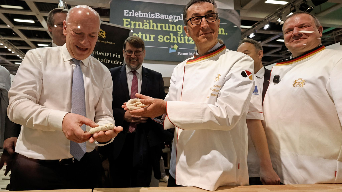 Bundesagrarminister Cem Özdemir und Berlins Regierender Bürgermeister Kai Wegner formen Brezeln beim Eröffnungsrundgang über das Messegelände der Grünen Woche. - Foto: Carsten Koall/dpa