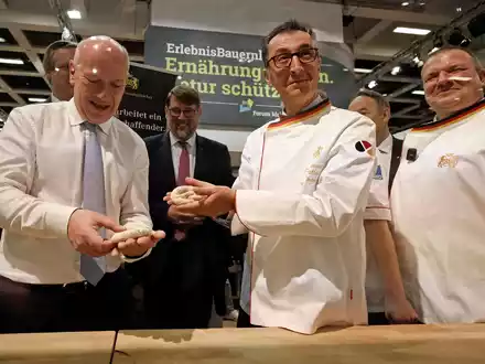 Bundesagrarminister Cem Özdemir und Berlins Regierender Bürgermeister Kai Wegner formen Brezeln beim Eröffnungsrundgang über das Messegelände der Grünen Woche. - Foto: Carsten Koall/dpa