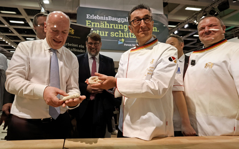 Bundesagrarminister Cem Özdemir und Berlins Regierender Bürgermeister Kai Wegner formen Brezeln beim Eröffnungsrundgang über das Messegelände der Grünen Woche. - Foto: Carsten Koall/dpa