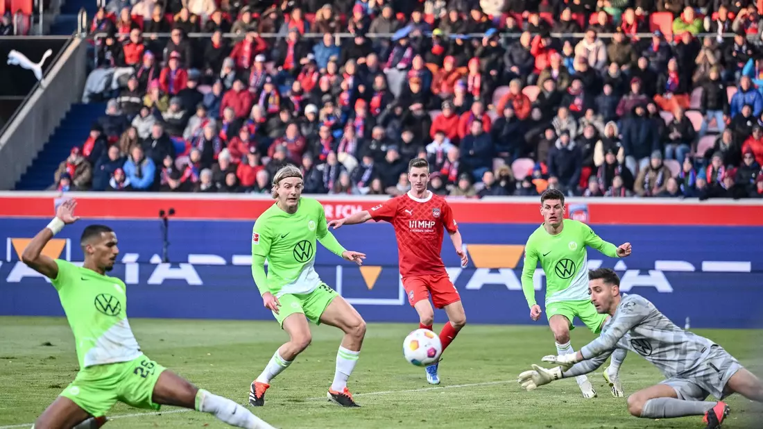 Wolfsburgs Moritz Jenz (l) traf beim 1:1 in Heidenheim ins eigene Tor. - Bild: Harry Langer/dpa