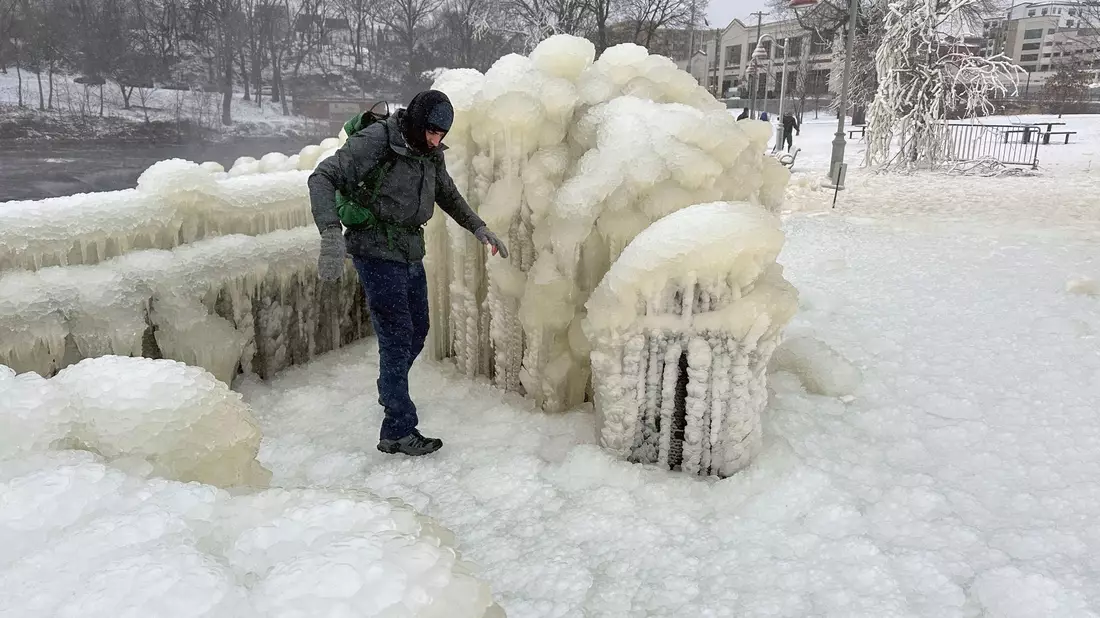 Unweit der Great-Falls-Wasserfälle von Paterson im US-Bundesstaat New Jersey geht ein Mann über eine dicke Eisschcht. - Bild: Ted Shaffrey/AP/dpa