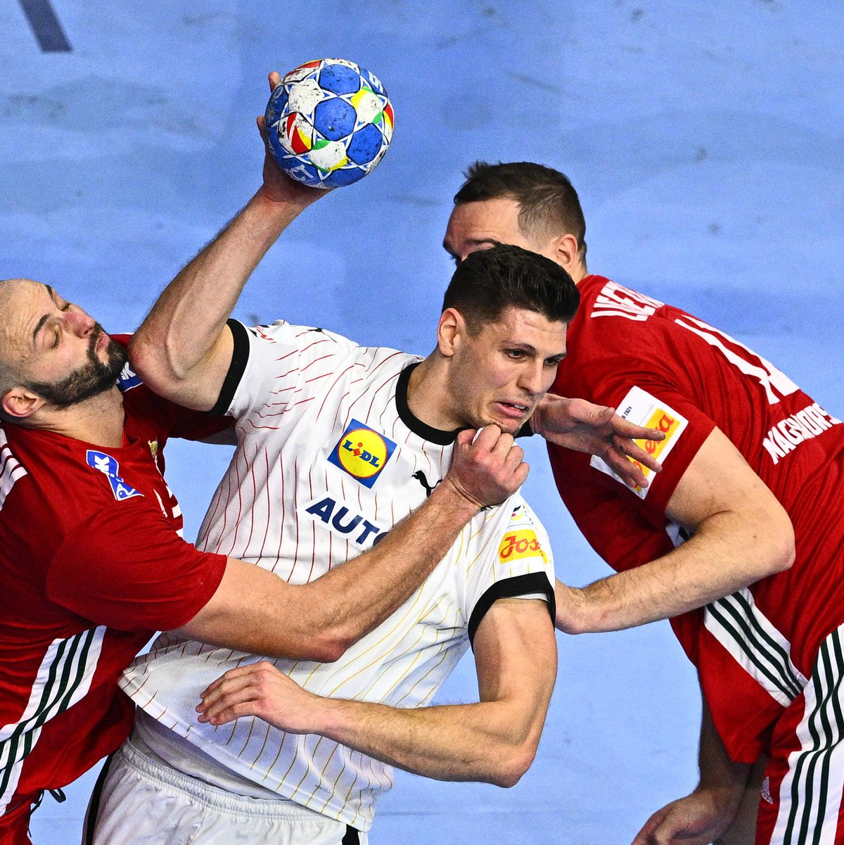 Sebastian Heymann (M) wird von zwei Ungarn verteidigt. - Foto: Tom Weller/dpa