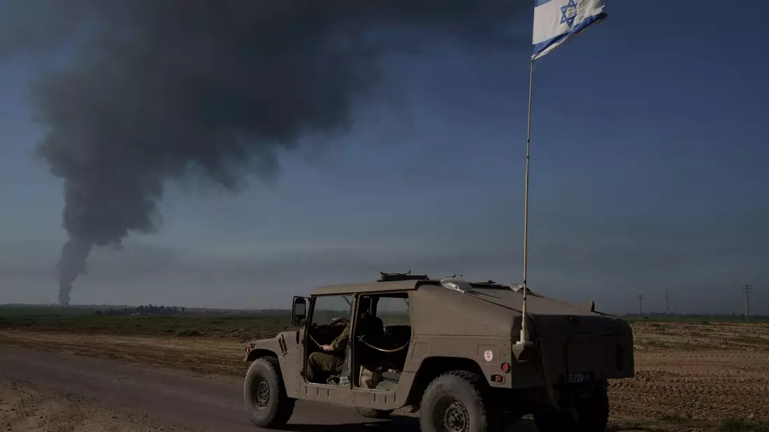Israelische Soldaten in der Nähe der Grenze zwischen Israel und dem Gazastreifen, während in dem Küstengebiet Rauch in den Himmel steigt. - Bild: Leo Correa/AP/dpa