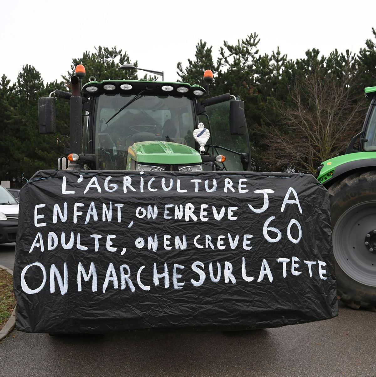 Landwirte vor einer Demonstration in der Nähe von Beauvais in Nordfrankreich. Auf dem Banner steht: Landwirtschaft, ein Kindheitstraum, der uns als Erwachsene umbringt. Die Welt ist aus den Fugen geraten. - Foto: Matthieu Mirville/AP/dpa