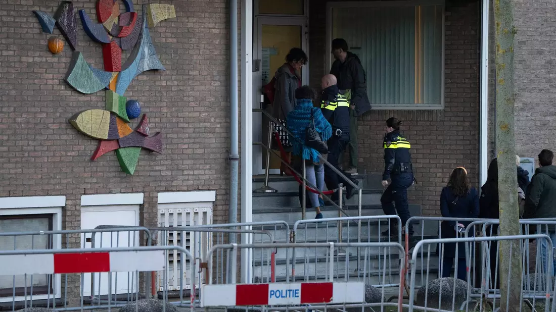 Zwei niederländische Polizeibeamte betreten das Hochsicherheitsgebäude des Gerichts. - Bild: Peter Dejong/AP/dpa