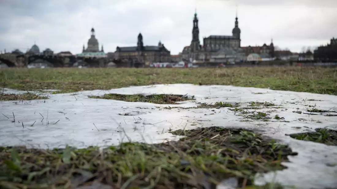Die Elbwiesen gegenüber der historischen Dresdner Altstadtkulisse sind vom letzten Hochwasser gefroren. - Bild: Robert Michael/dpa