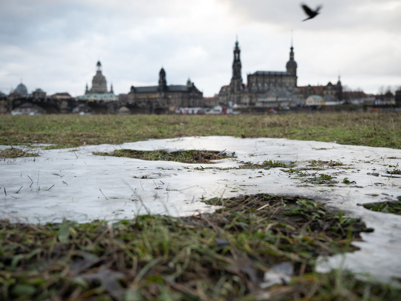 Die Elbwiesen gegenüber der historischen Dresdner Altstadtkulisse sind vom letzten Hochwasser gefroren. - Foto: Robert Michael/dpa