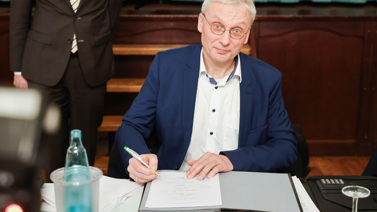Kai Uwe Evers, der Bürgermeister von Norderwöhrden, unterzeichnet einen Durchführungsvertrag. - Foto: Christian Charisius/dpa