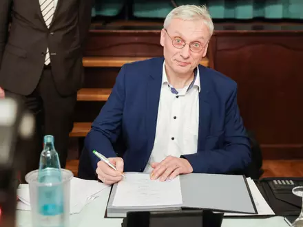 Kai Uwe Evers, der Bürgermeister von Norderwöhrden, unterzeichnet einen Durchführungsvertrag. - Foto: Christian Charisius/dpa