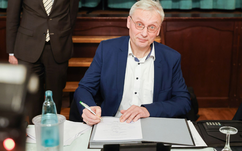 Kai Uwe Evers, der Bürgermeister von Norderwöhrden, unterzeichnet einen Durchführungsvertrag. - Foto: Christian Charisius/dpa